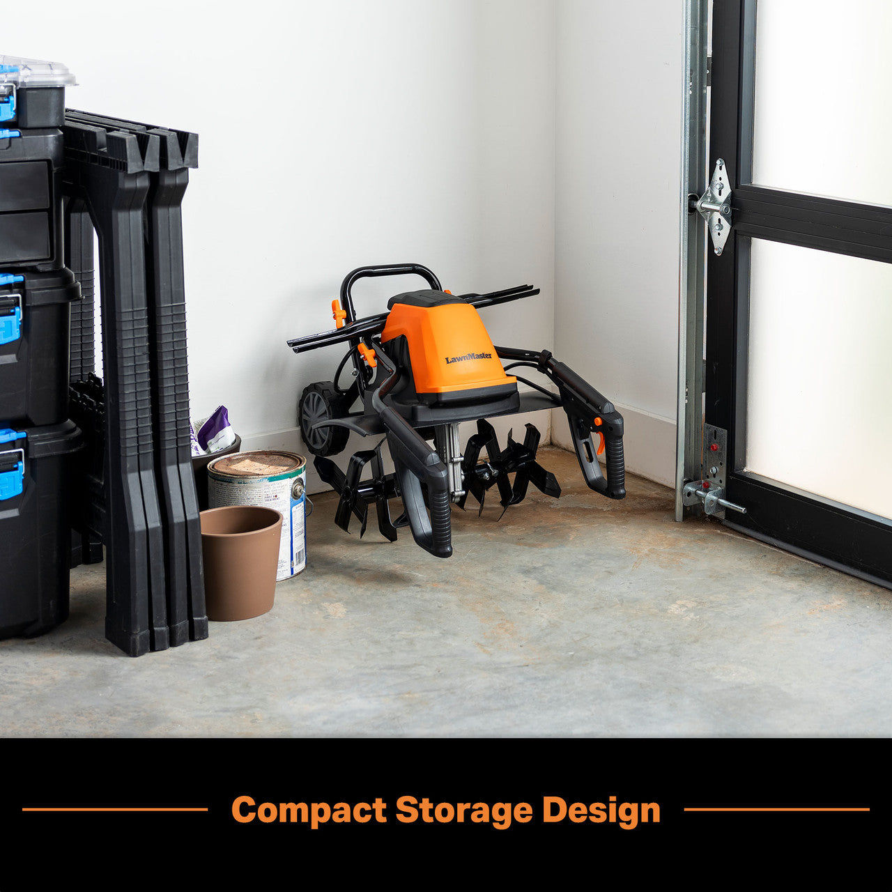 Orange and black tiller in a garage with storage bins and tools.
