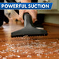 Image of a hand holding a nozzle vacuuming up broken glass from a hardwood floor with text that reads, "powerful suction."
