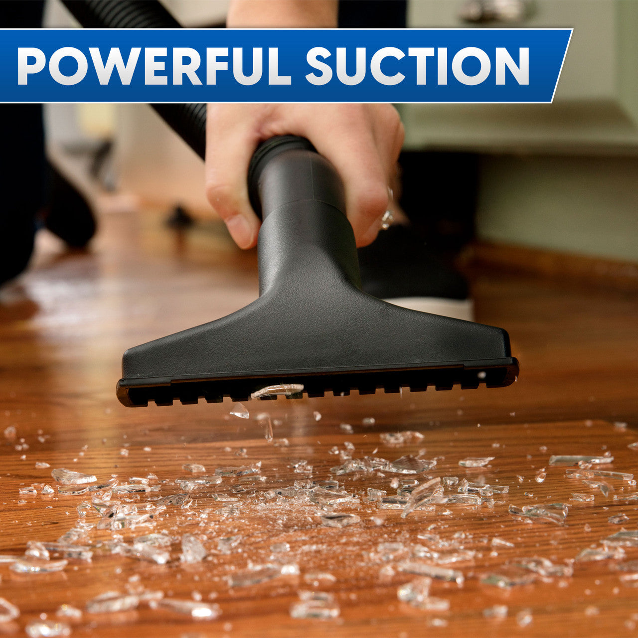 Image of a hand holding a nozzle vacuuming up broken glass from a hardwood floor with text that reads, "powerful suction."