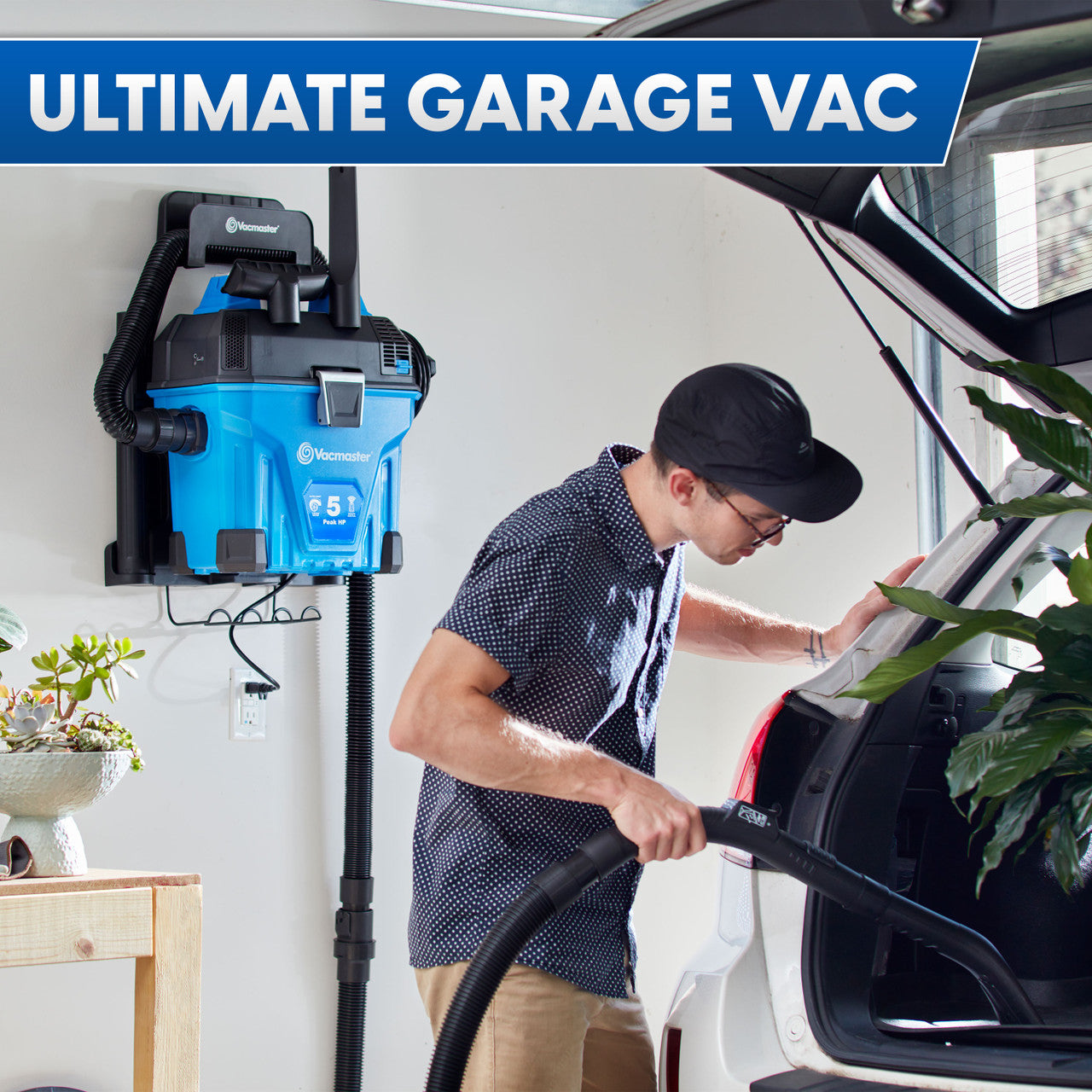 Person using a garage vacuum cleaner with text 'Ultimate Garage Vac' above.