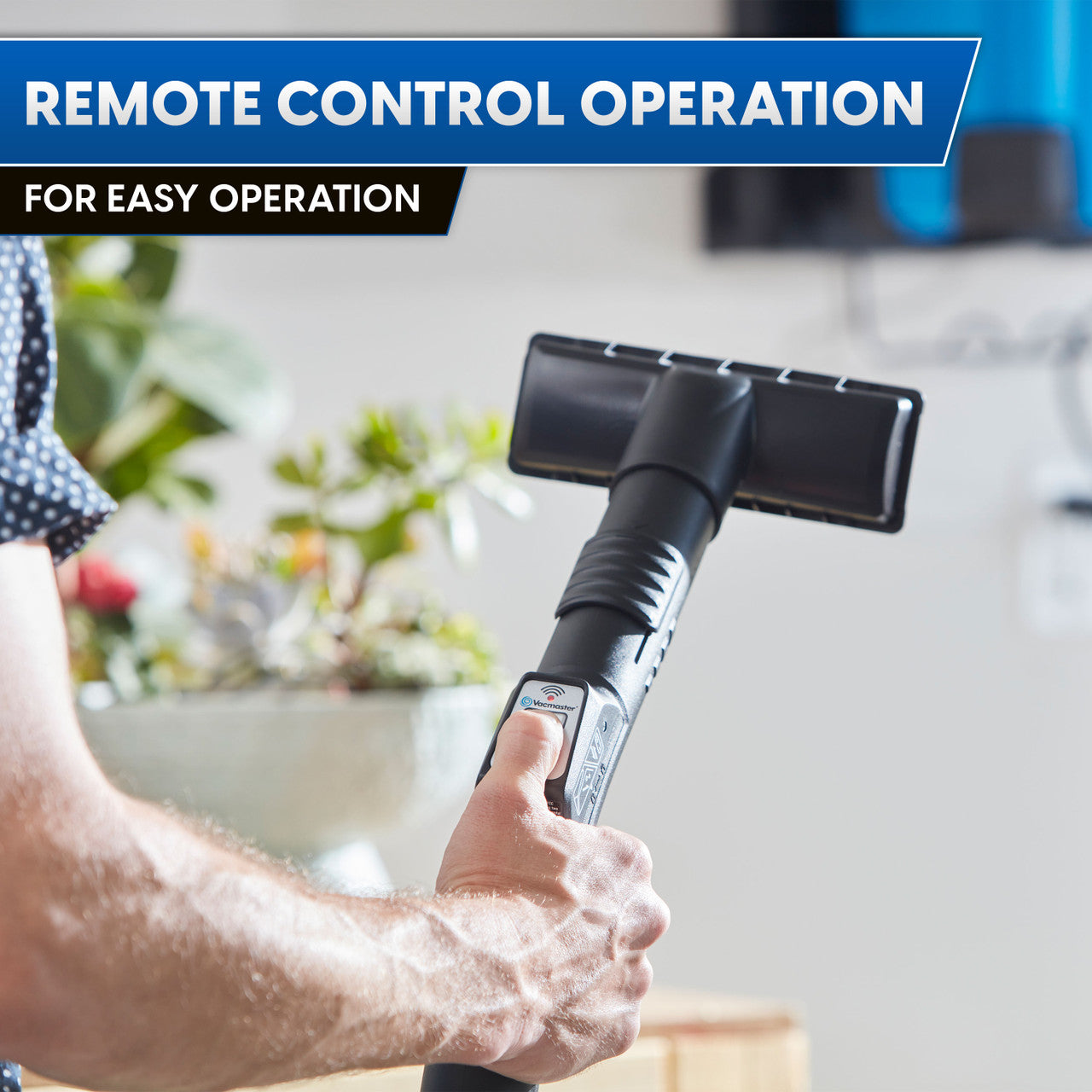 Hand holding a black vacuum hose with text 'Remote Control Operation for Easy Operation' on a blurred background.